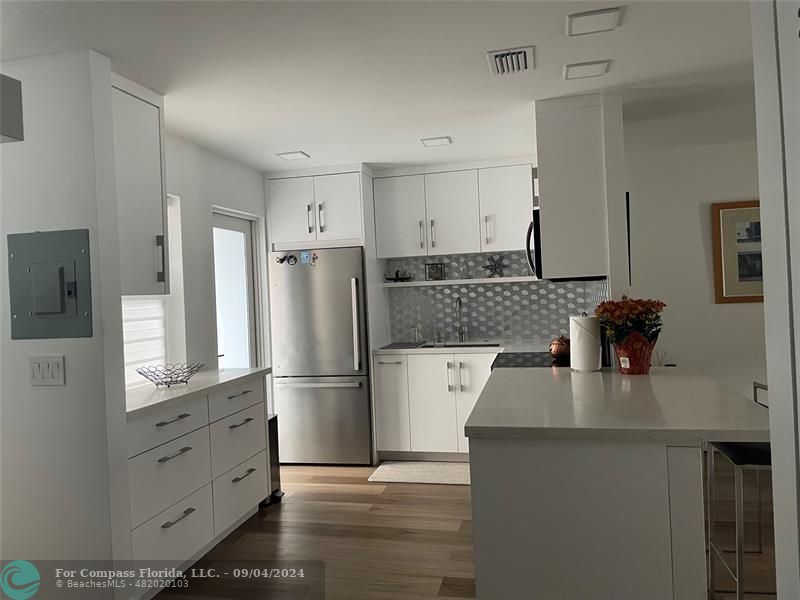 a kitchen with white cabinets and stainless steel appliances