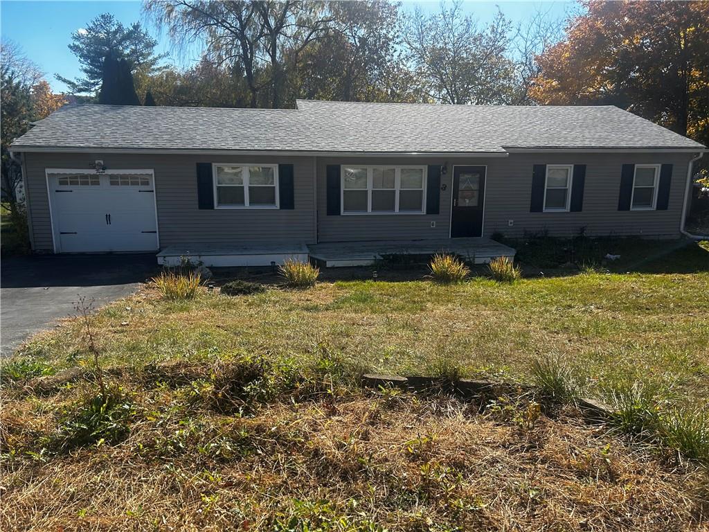 Ranch-style home with a front lawn and a garage