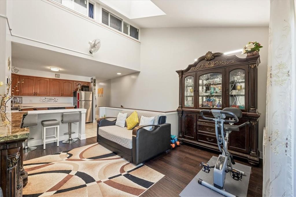 a living room with furniture a flat screen tv and floor to ceiling window