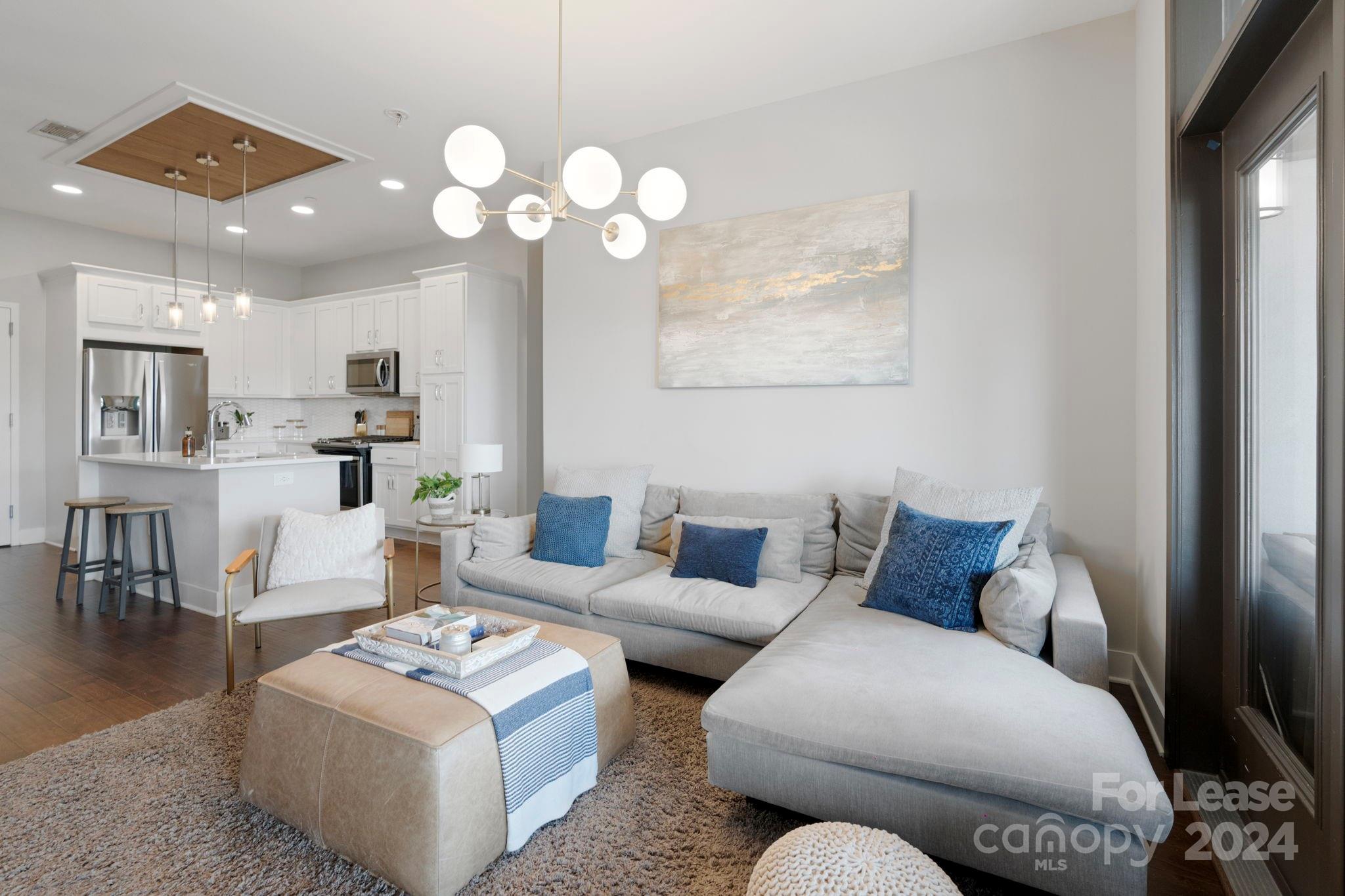 a living room with furniture a chandelier and a painting