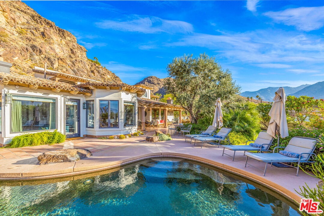 a view of a house with pool and chairs