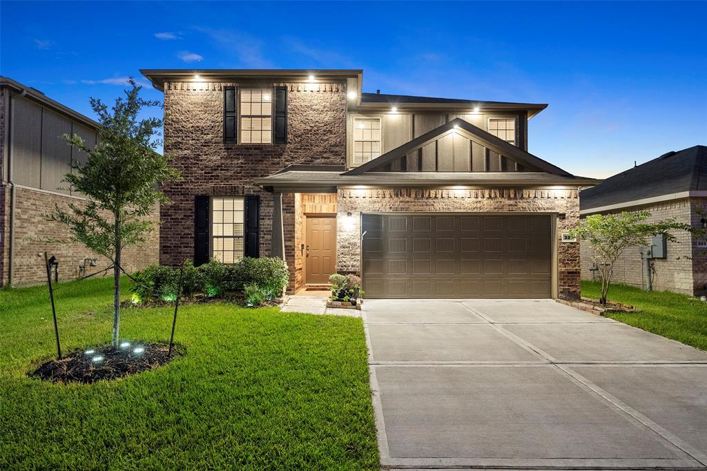 a front view of a house with a yard and garage