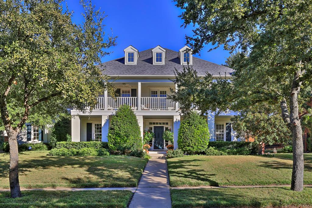 a front view of a house with yard and green space