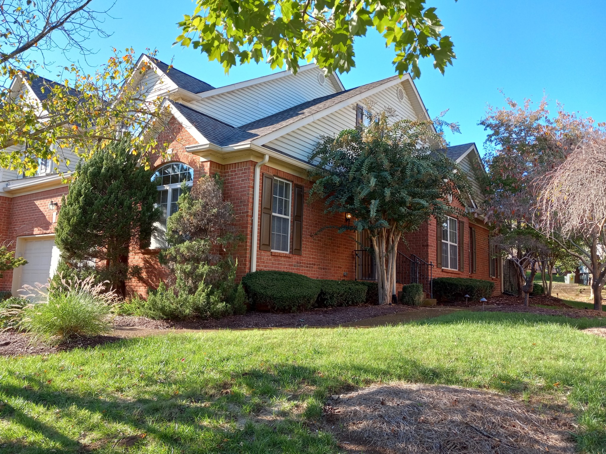 a front view of a house with a garden and trees