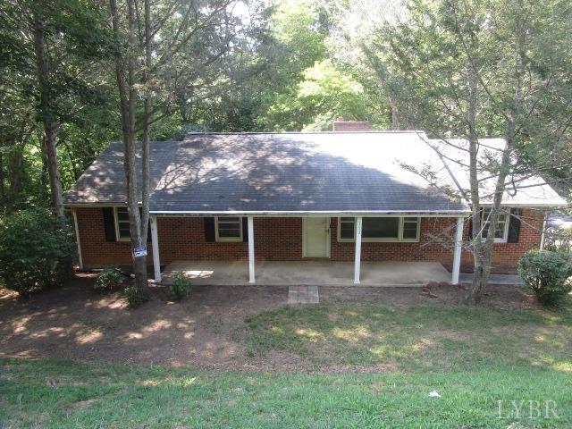 a view of a house with a yard and large tree