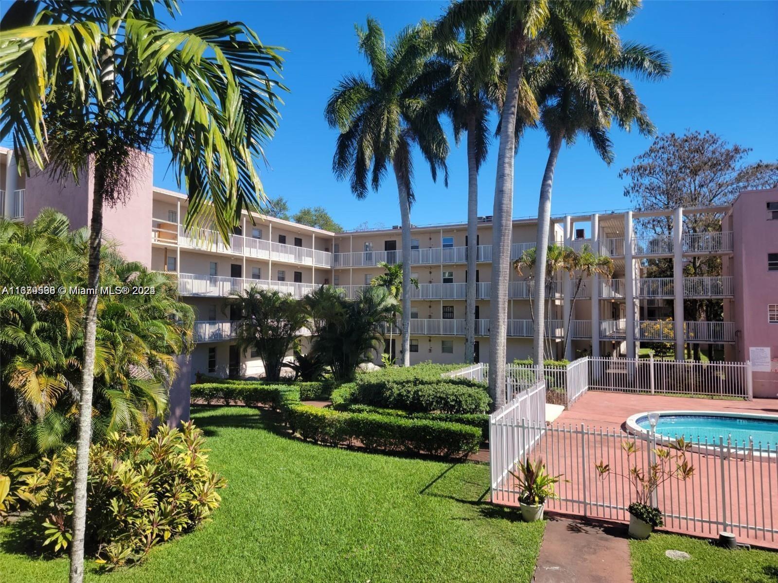 a view of a house with a yard and palm trees