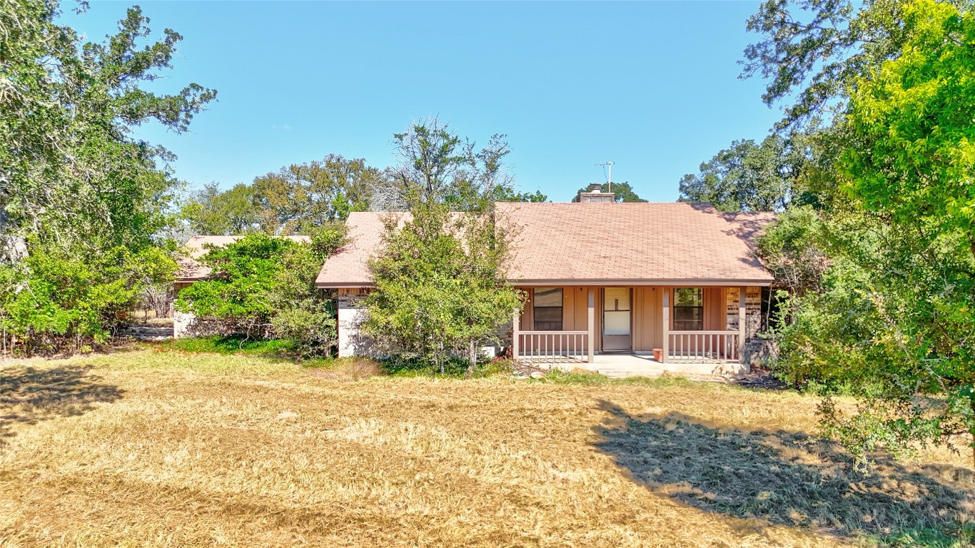 a front view of house with yard and trees around