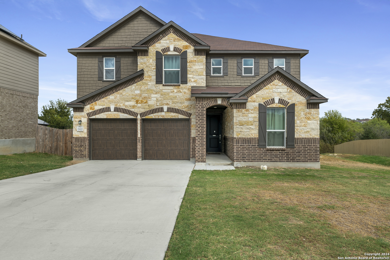 a front view of a house with a garden and yard