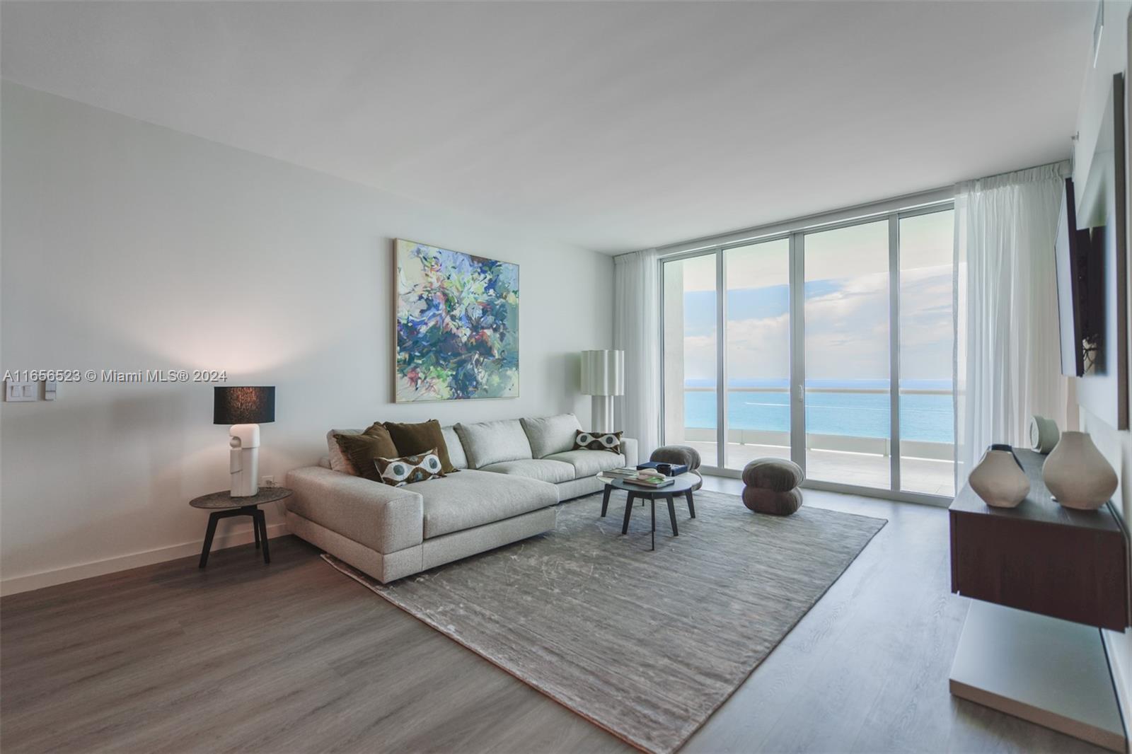 a living room with furniture and a large window with rug