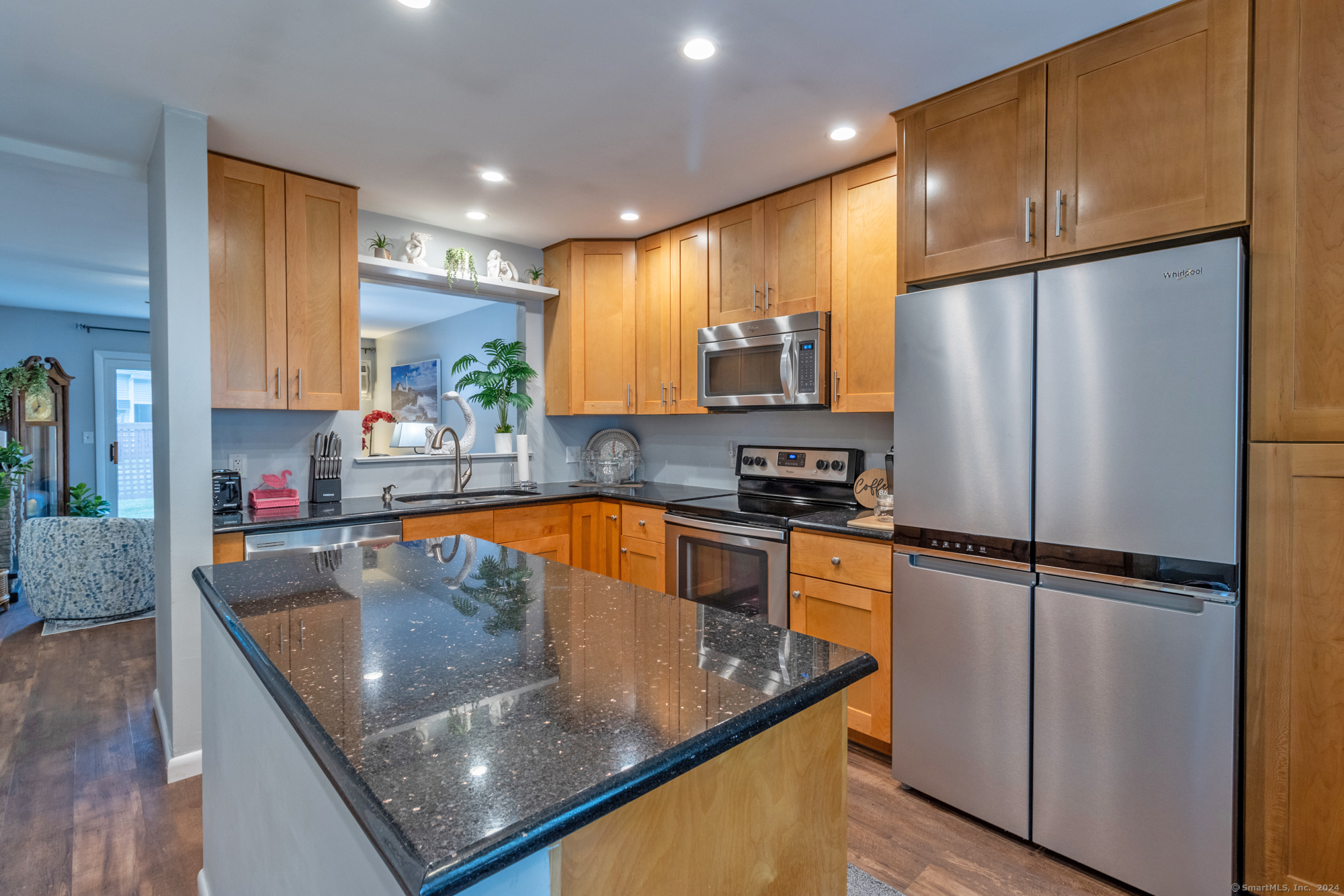 a kitchen with stainless steel appliances granite countertop a refrigerator a sink and a stove