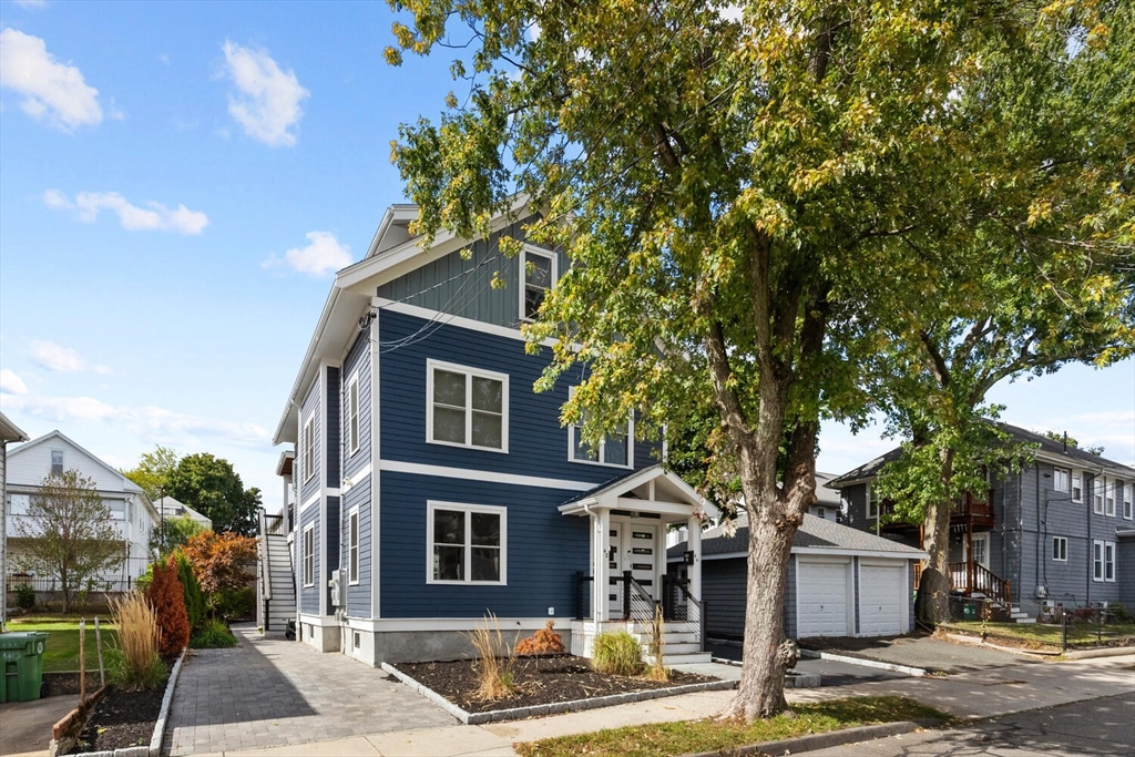 a front view of a house with a tree