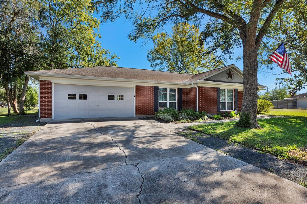 Charming single-story home featuring a brick facade, two-car garage, and mature landscaping.