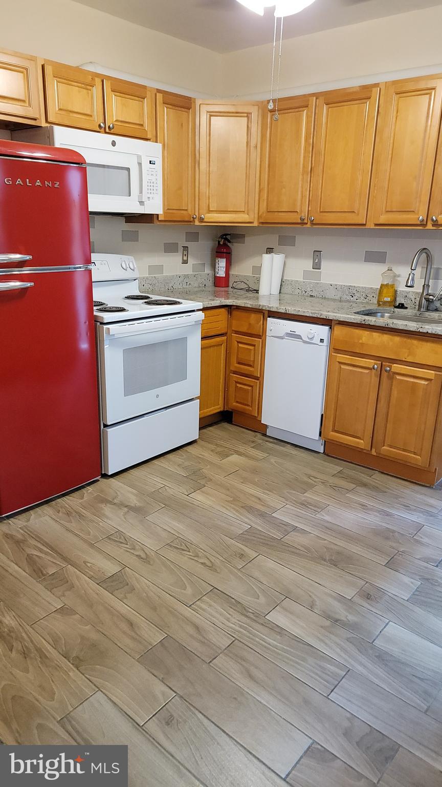 a kitchen with stainless steel appliances granite countertop a stove a sink dishwasher and a refrigerator