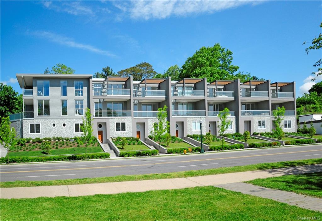 a front view of a residential apartment building with a yard