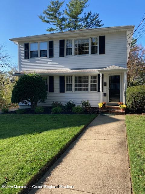 a front view of a house with a yard and potted plants