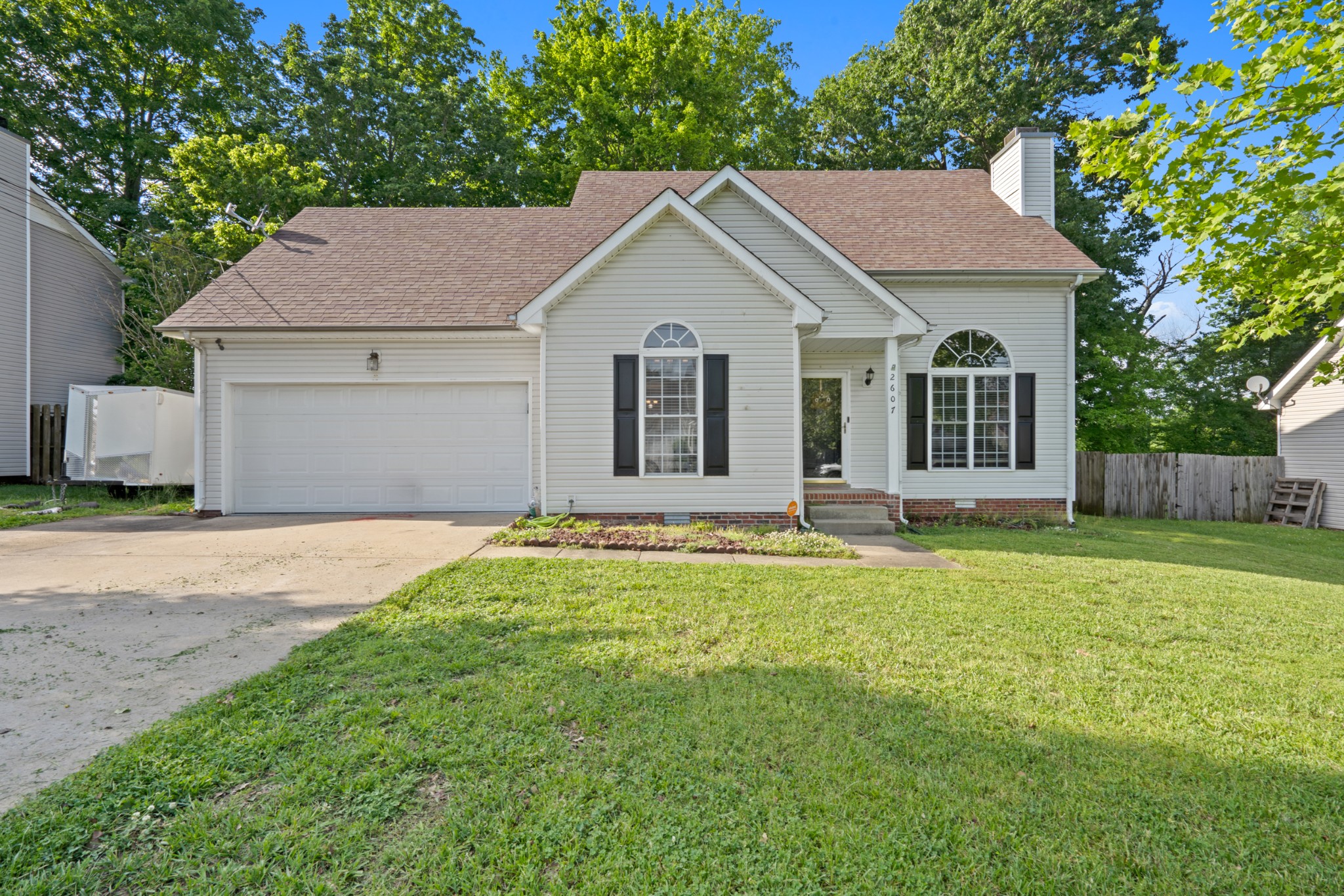 a front view of a house with a garden and yard