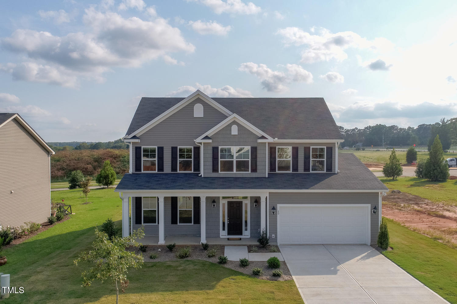 a aerial view of a house next to a big yard and large trees