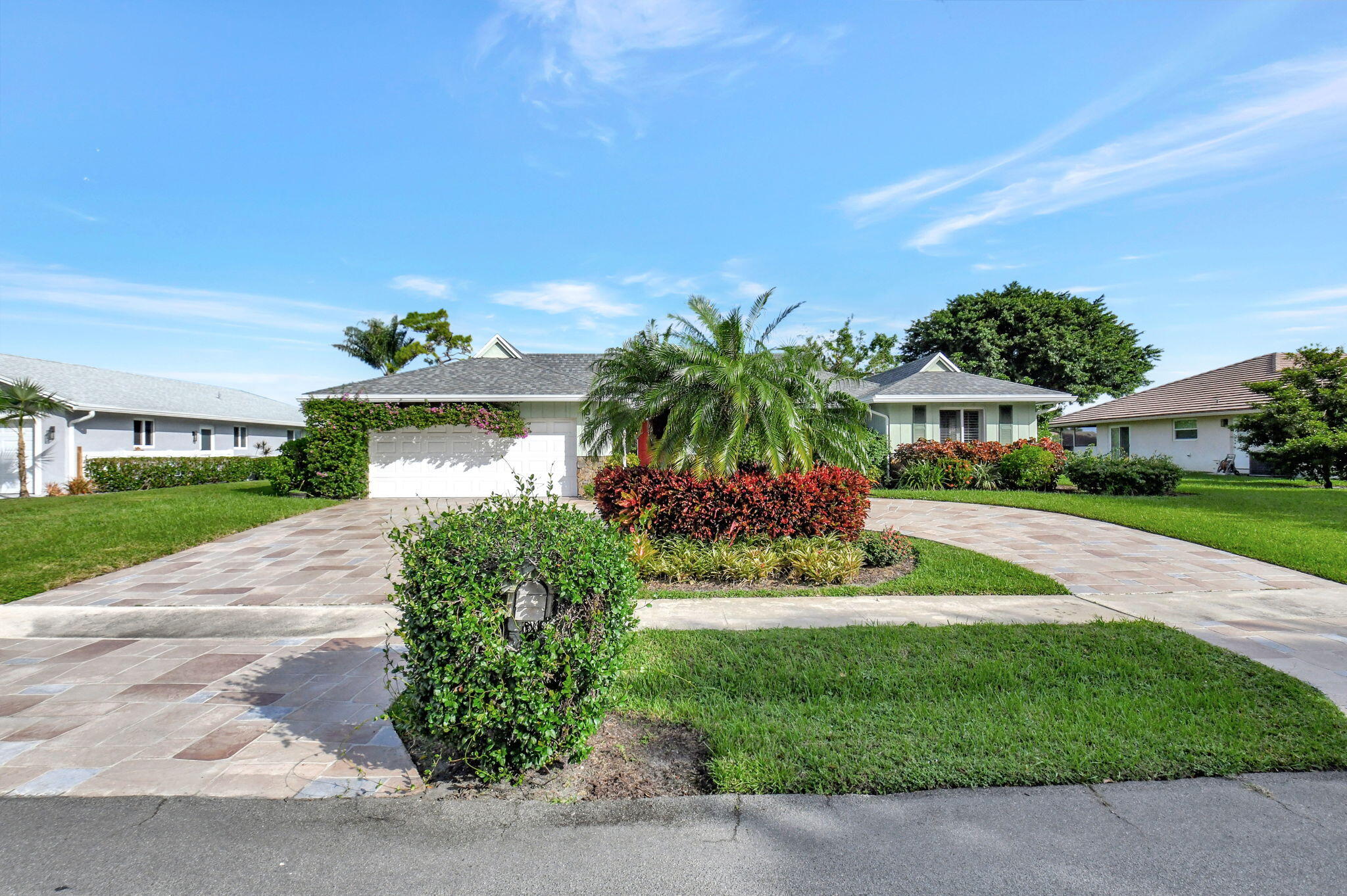 a front view of a house with a yard and potted plants