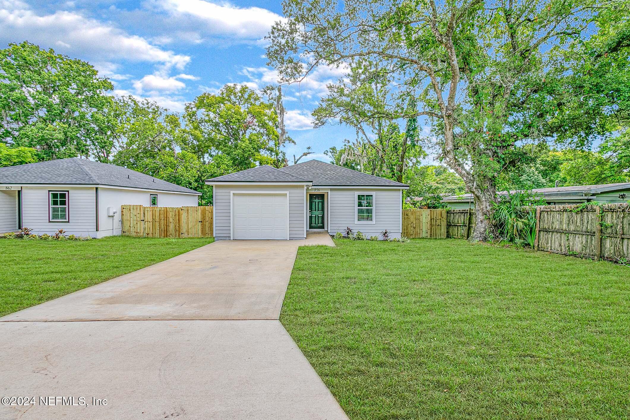 a front view of a house with a garden and yard