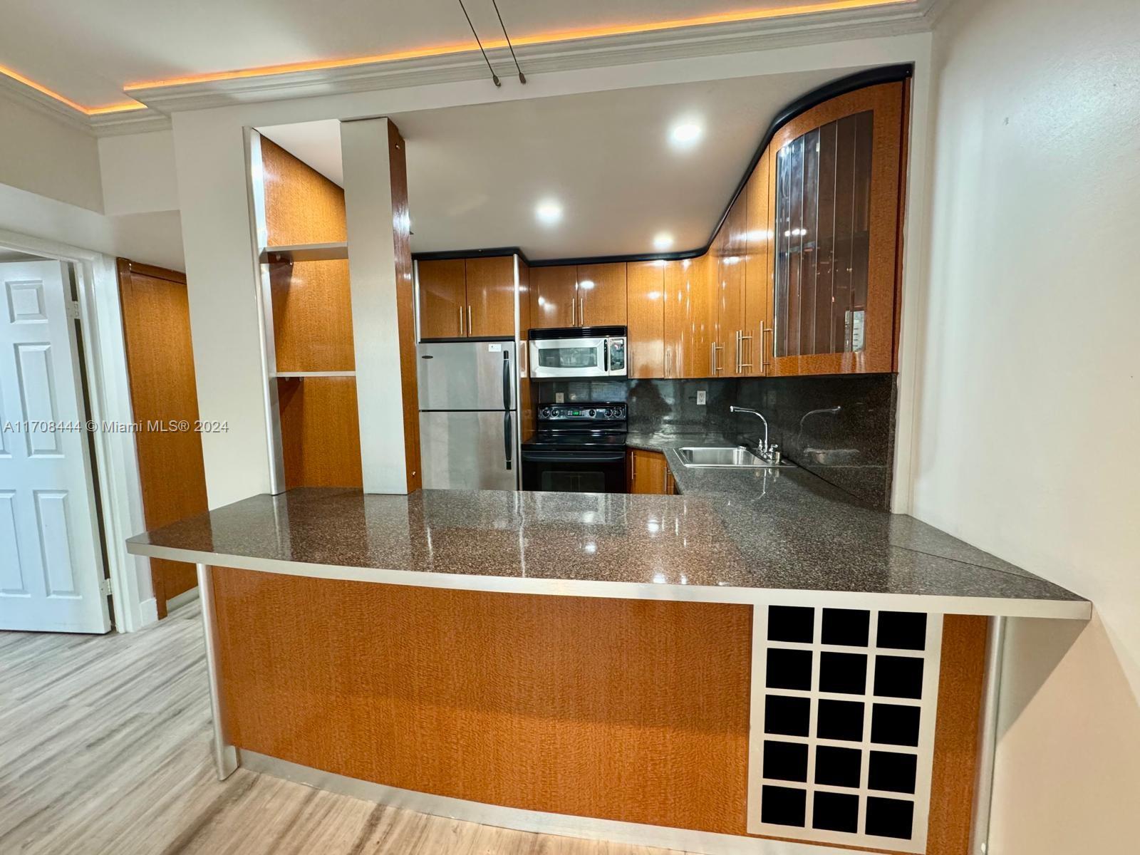 a view of kitchen with granite countertop a sink and microwave