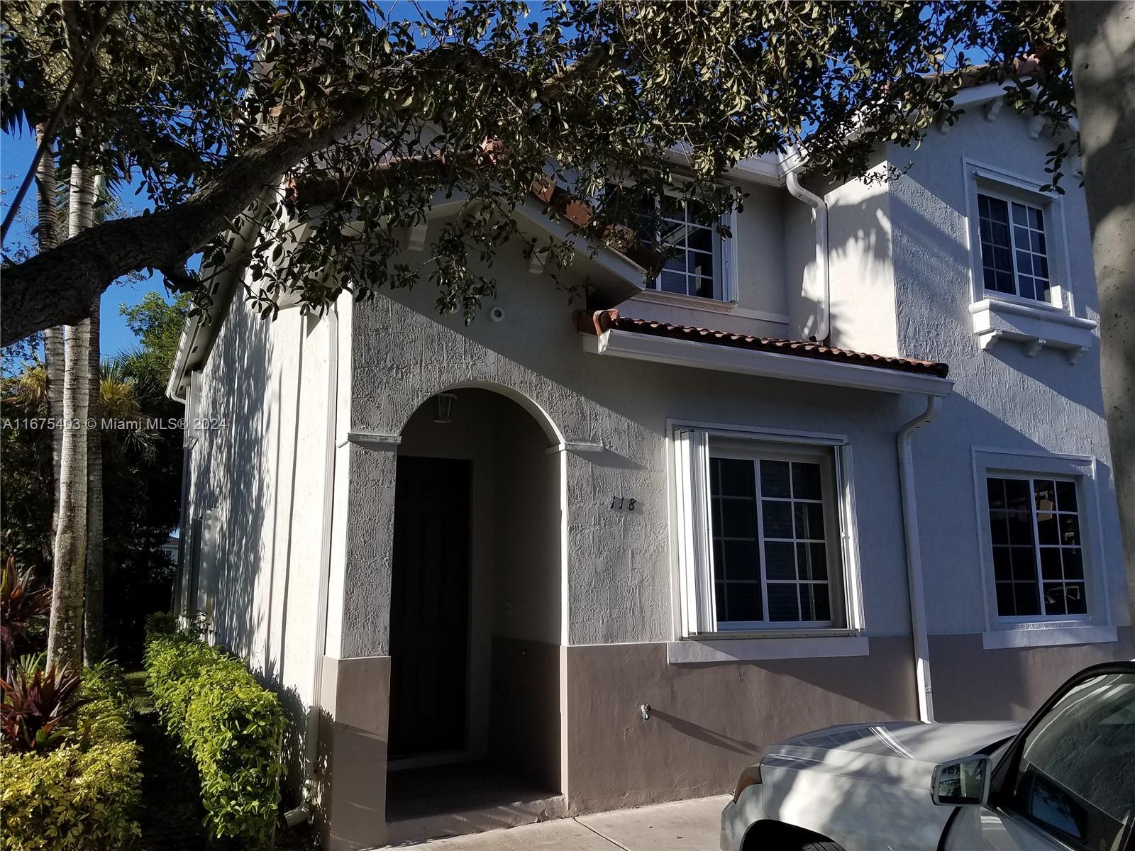 a front view of a house with a tree