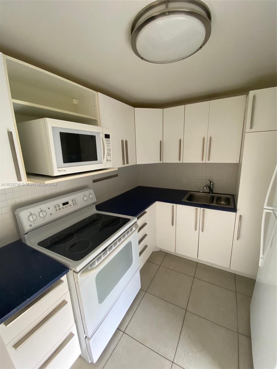 a kitchen with stainless steel appliances a stove a microwave and white cabinets