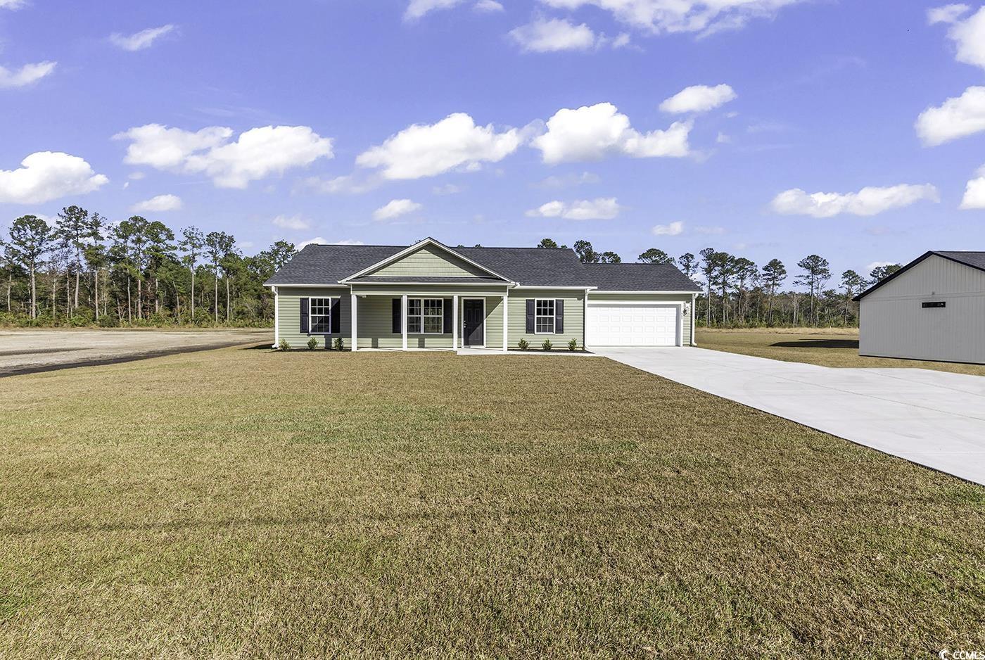 Single story home featuring covered porch, a garag