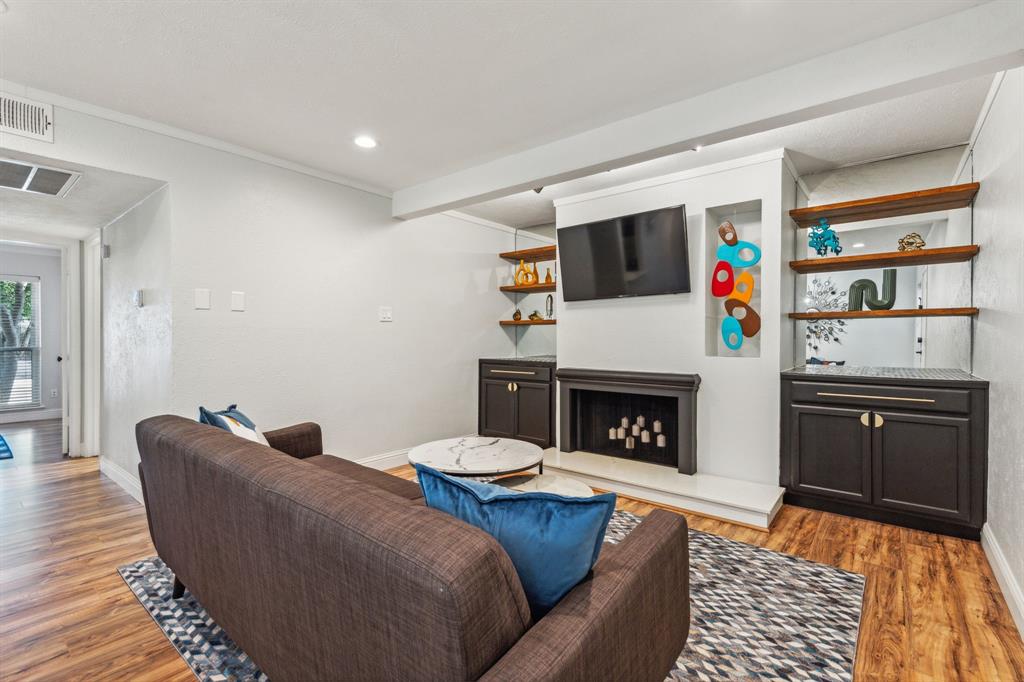 a living room with furniture a flat screen tv and a fireplace