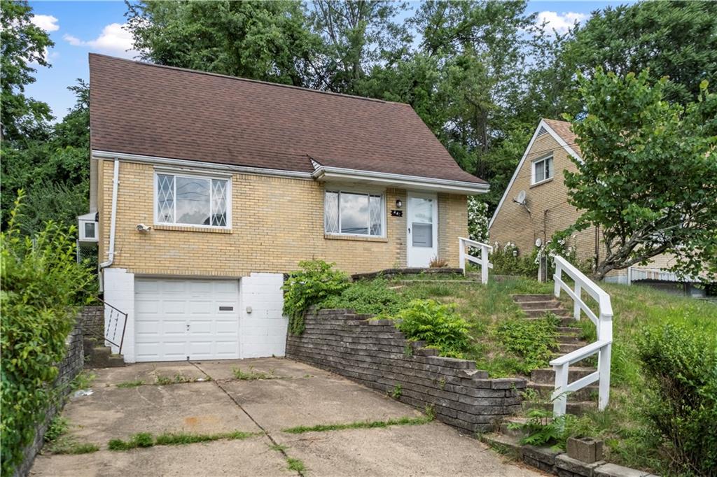 front view of house with a yard and potted plants