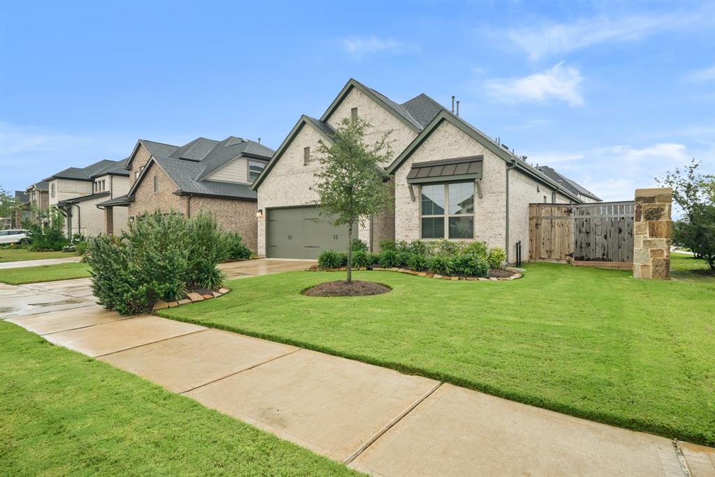 a view of a house with a big yard plants and large trees