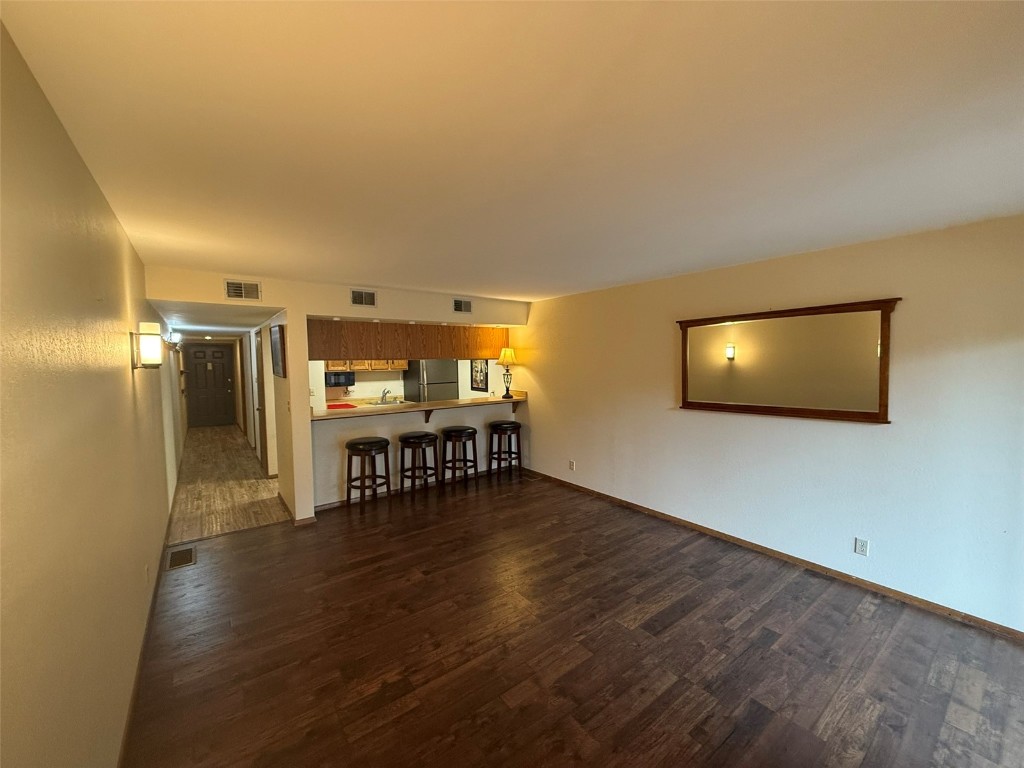 a view of a living room and a hallway with wooden floor