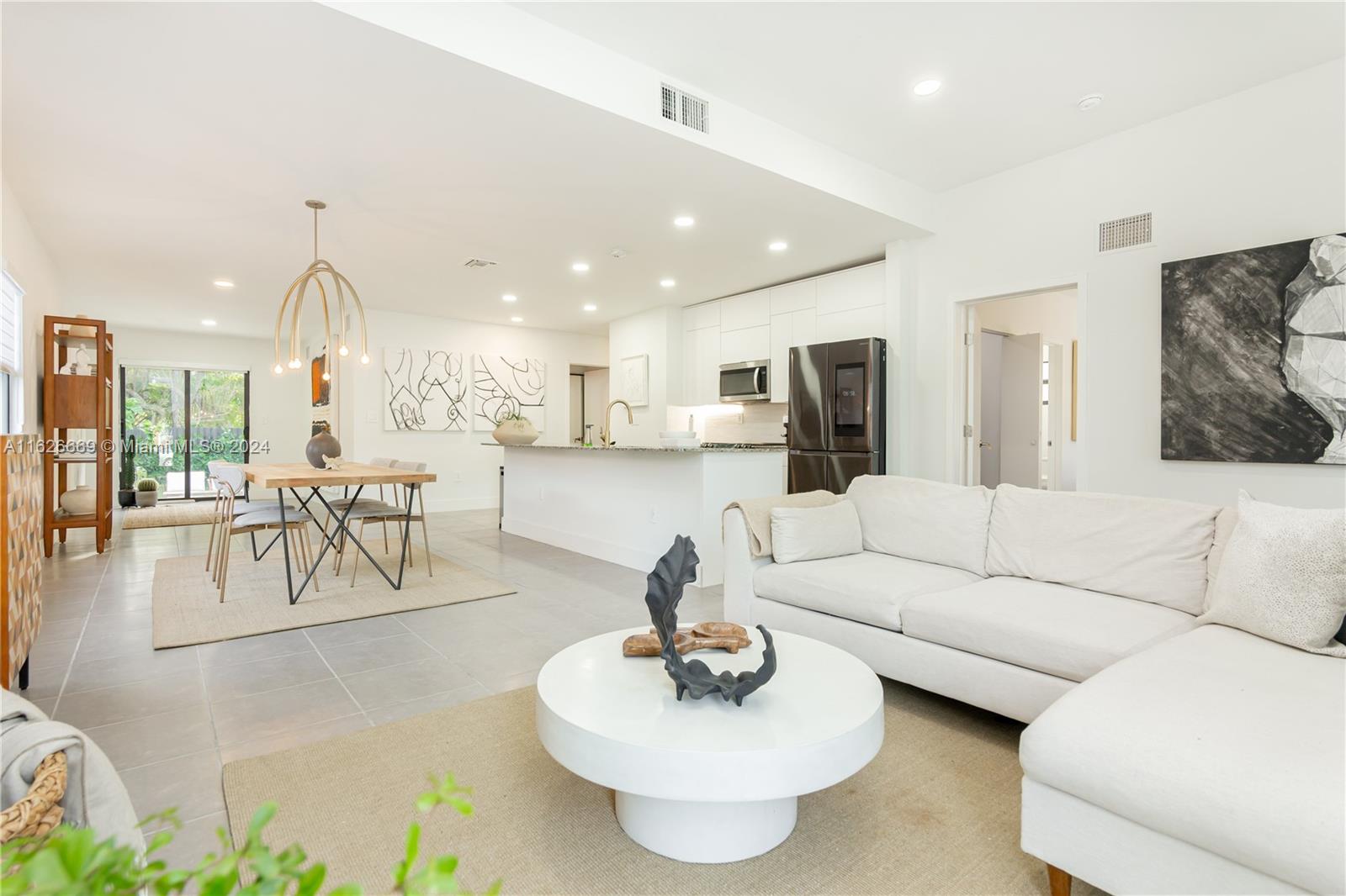 a living room with furniture and a dining table with kitchen view