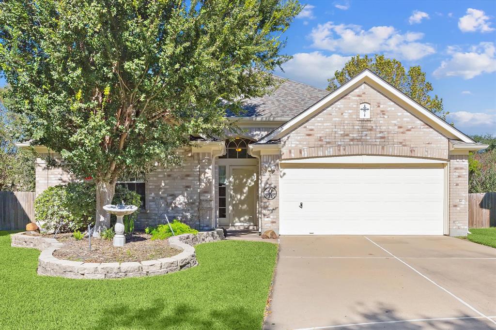 This is a single-story brick home featuring a two-car garage, nestled nicely in a cul-de-sac with an inviting entrance with decorative touches.