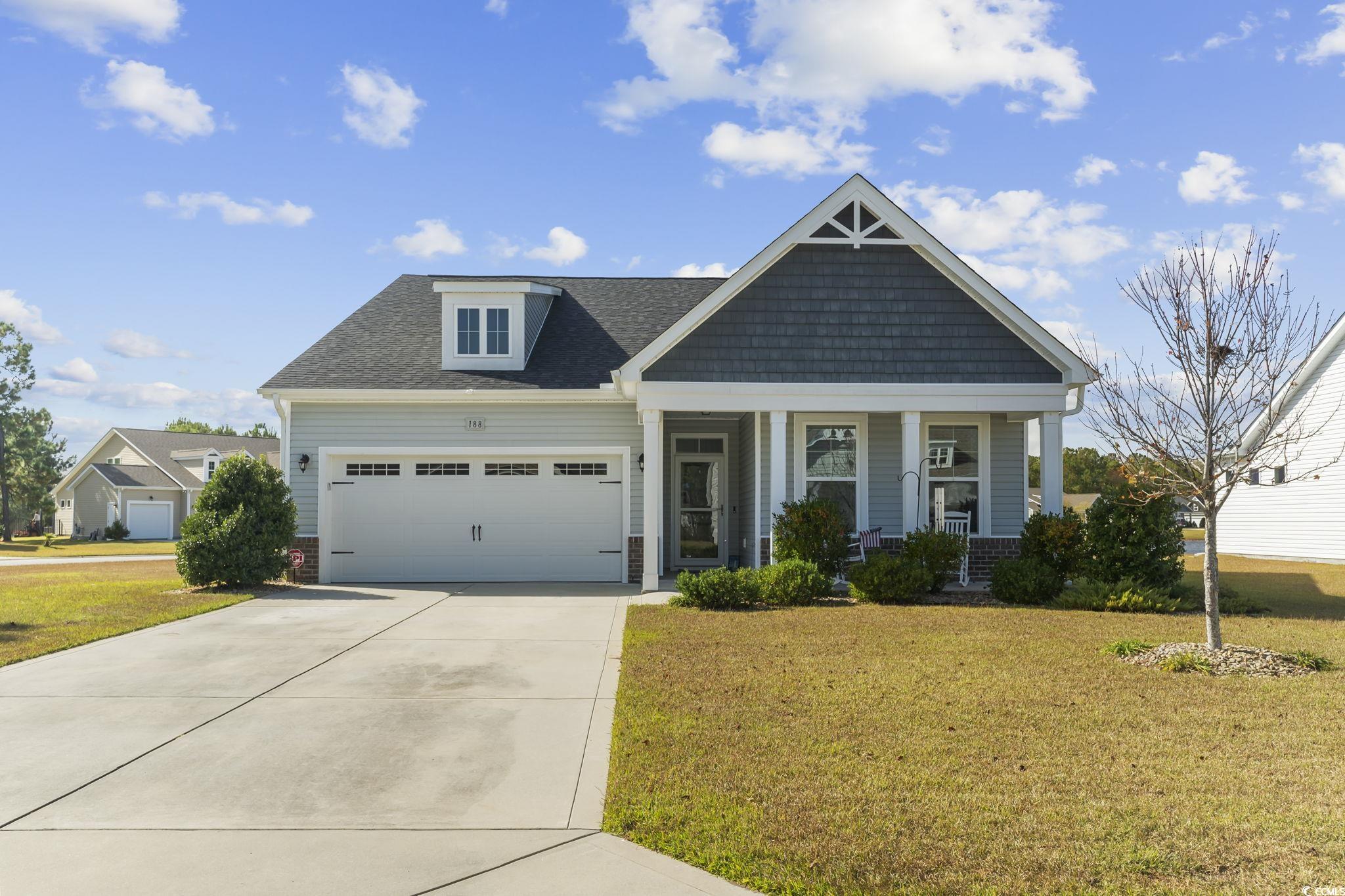 Craftsman-style home featuring a front yard, cover