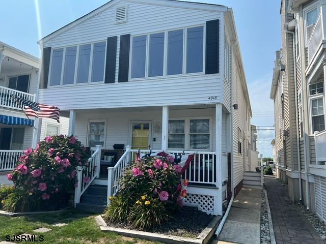 a view of a house that has a flower garden