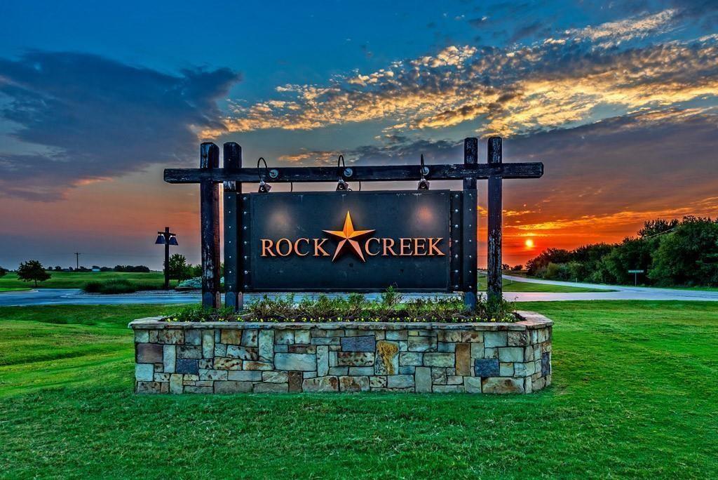 a view of a park that has a sign on the side of the road