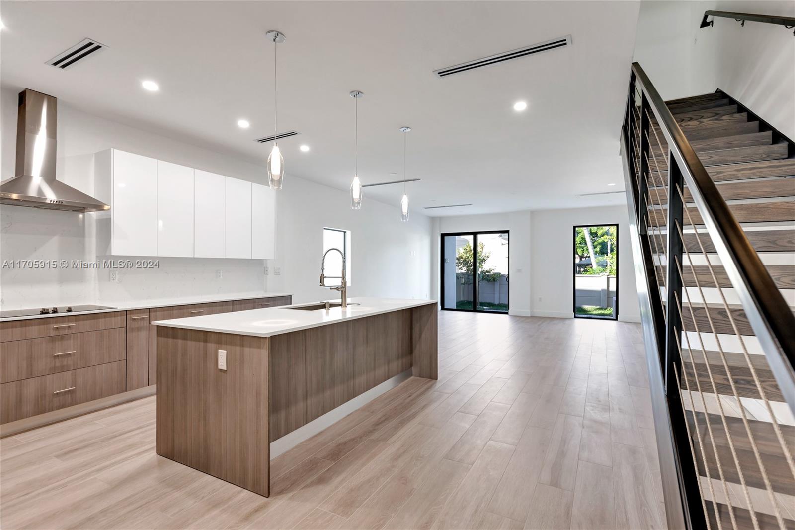 a large kitchen with stainless steel appliances granite countertop a lot of counter space and wooden floors