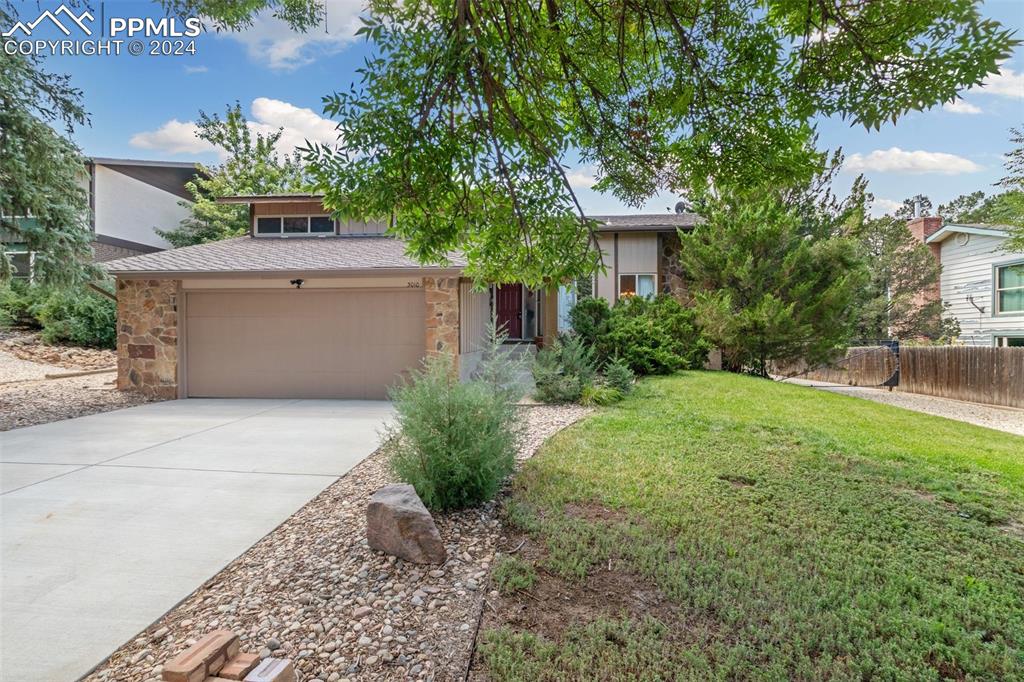 View of front of property with a front lawn and a garage