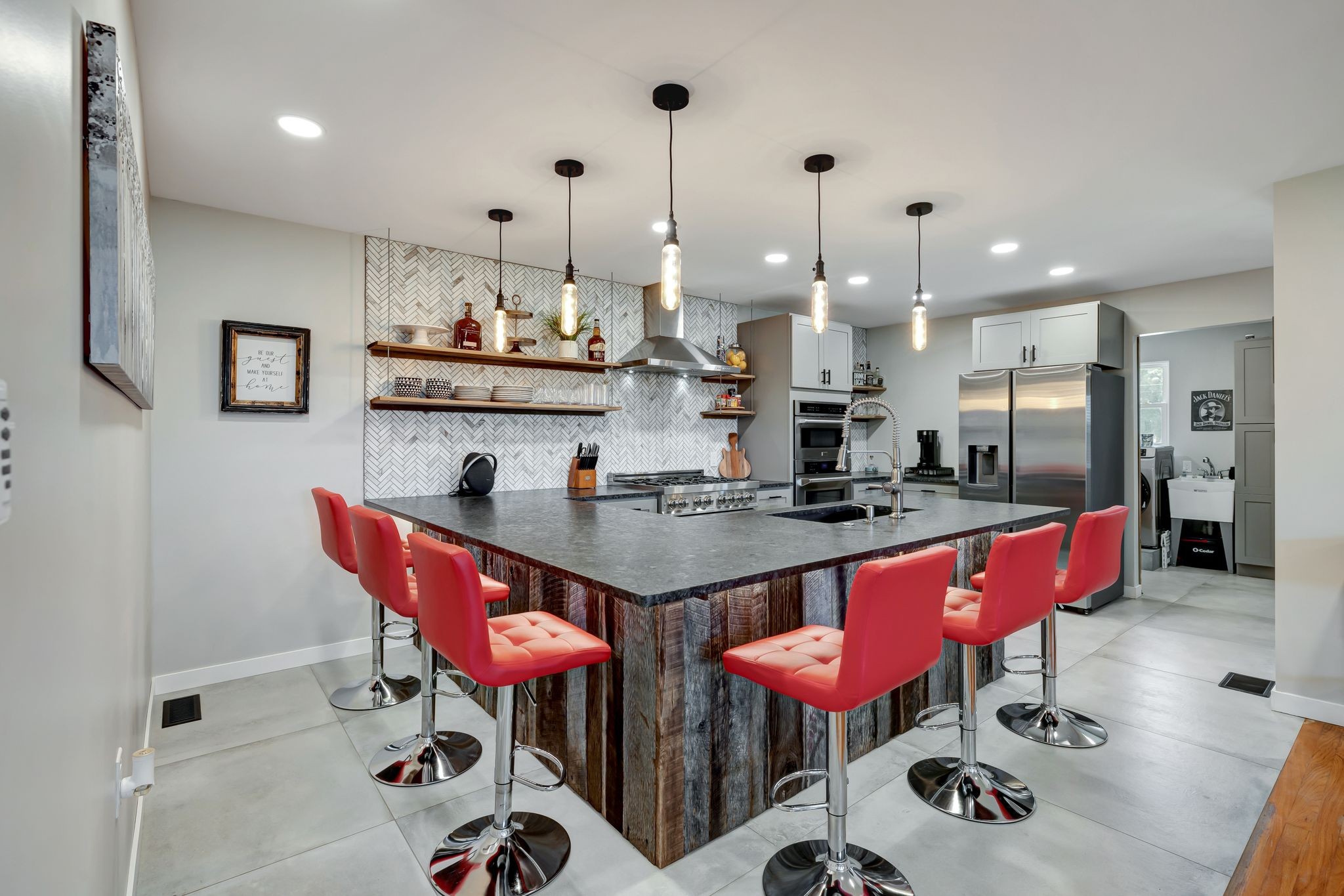 a kitchen with stainless steel appliances kitchen island granite countertop a table chairs and a view of living room