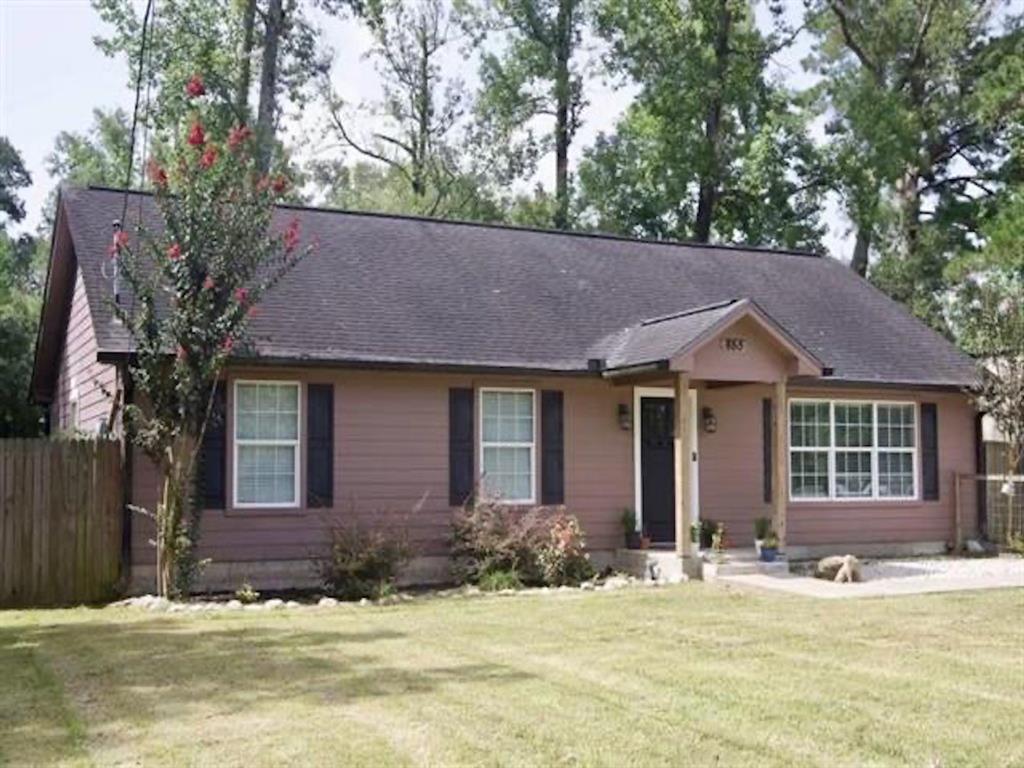 a view of house with outdoor space and tree in front of it