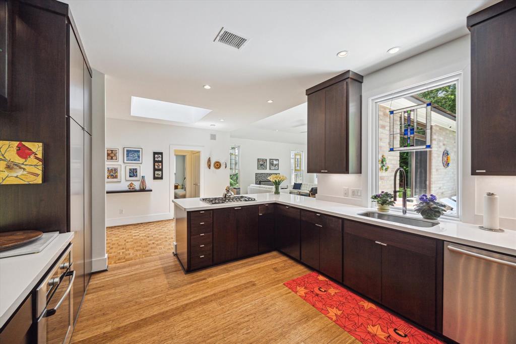 a large kitchen with wooden floors and stainless steel appliances