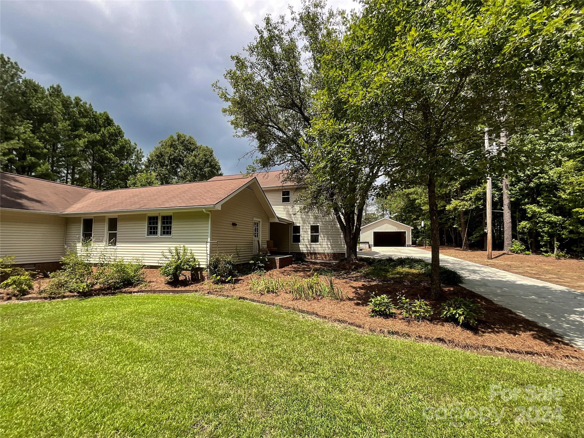 a front view of a house with a yard and trees