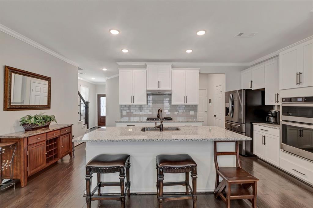 a kitchen with refrigerator and chairs