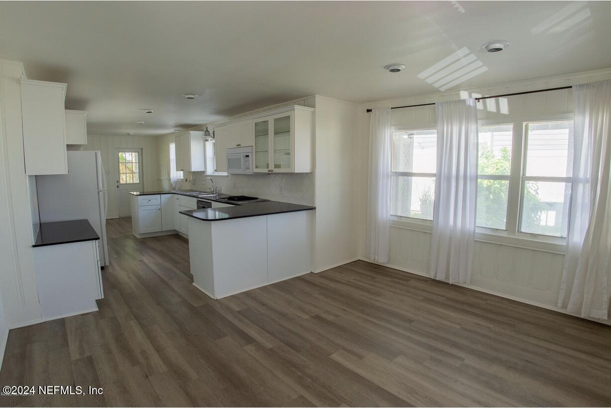 a kitchen with granite countertop a refrigerator and wooden cabinets