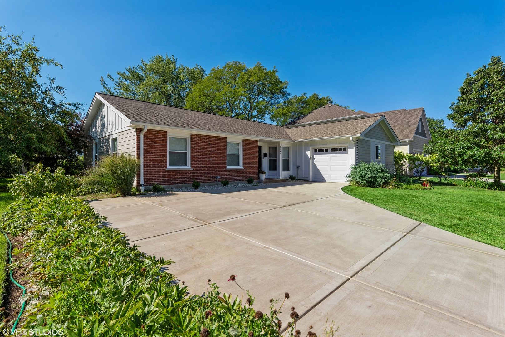 a front view of a house with yard and green space