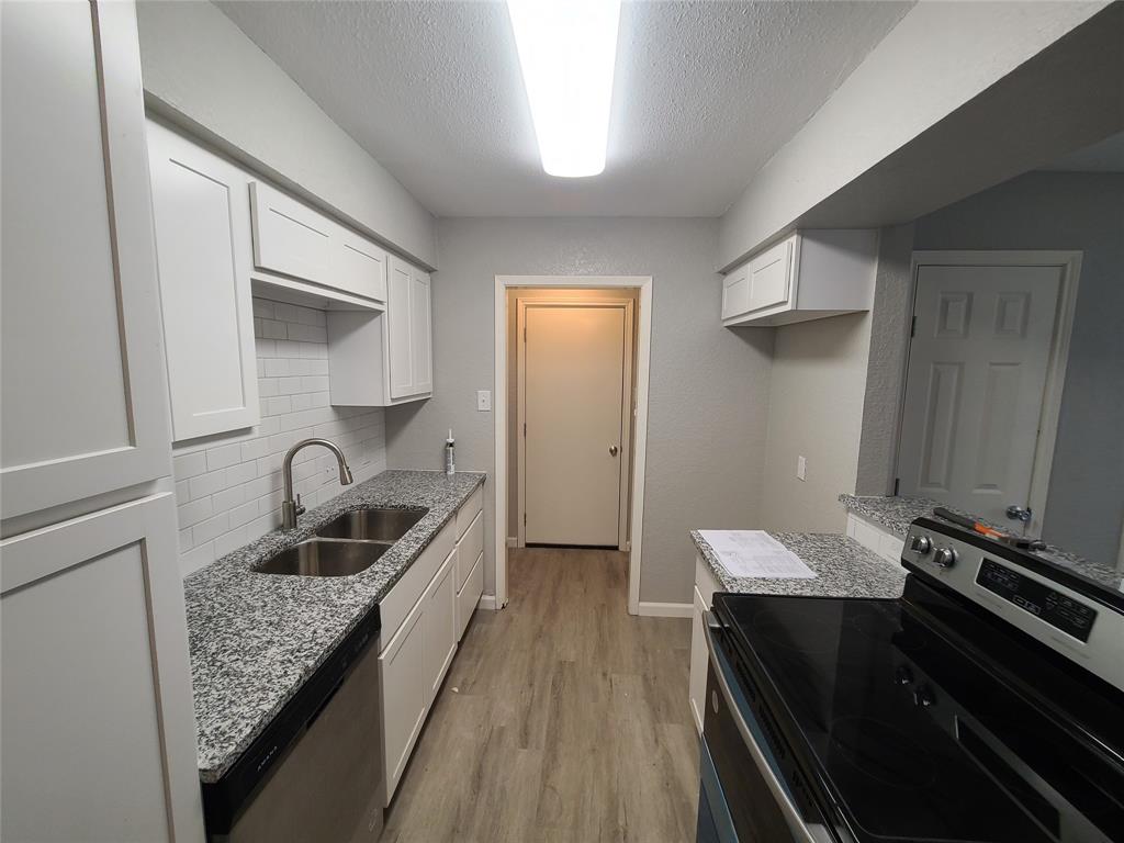 a kitchen with a sink stove and cabinets