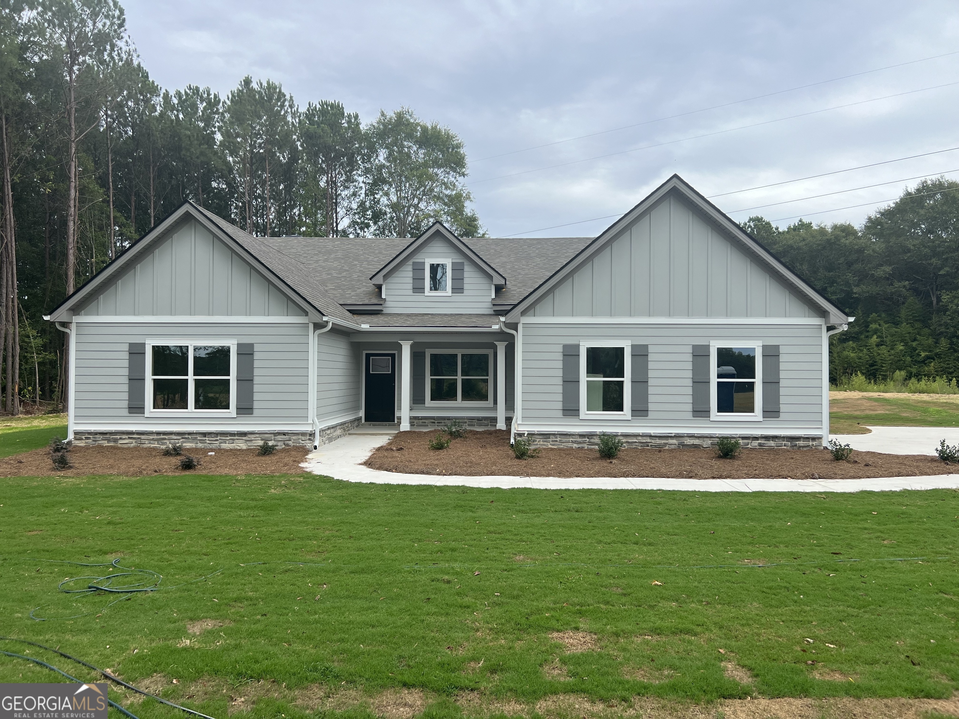 a front view of house with a garden and trees