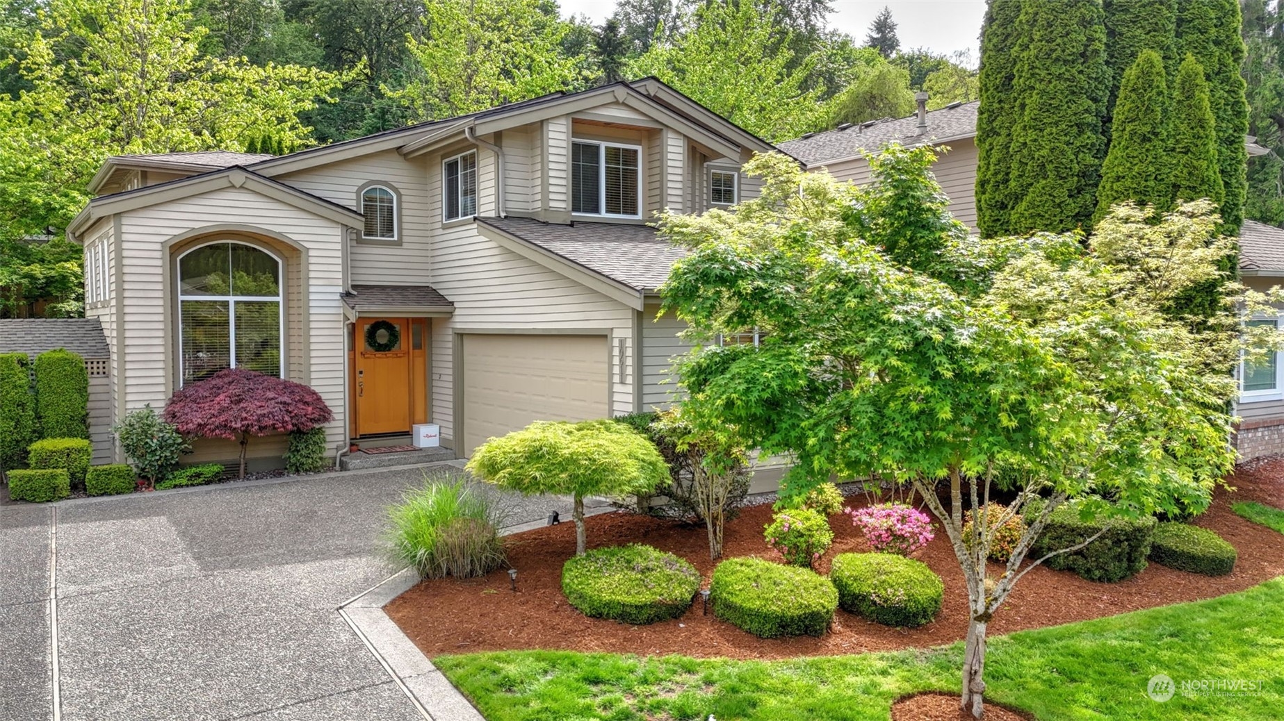 a front view of a house with a yard and potted plants