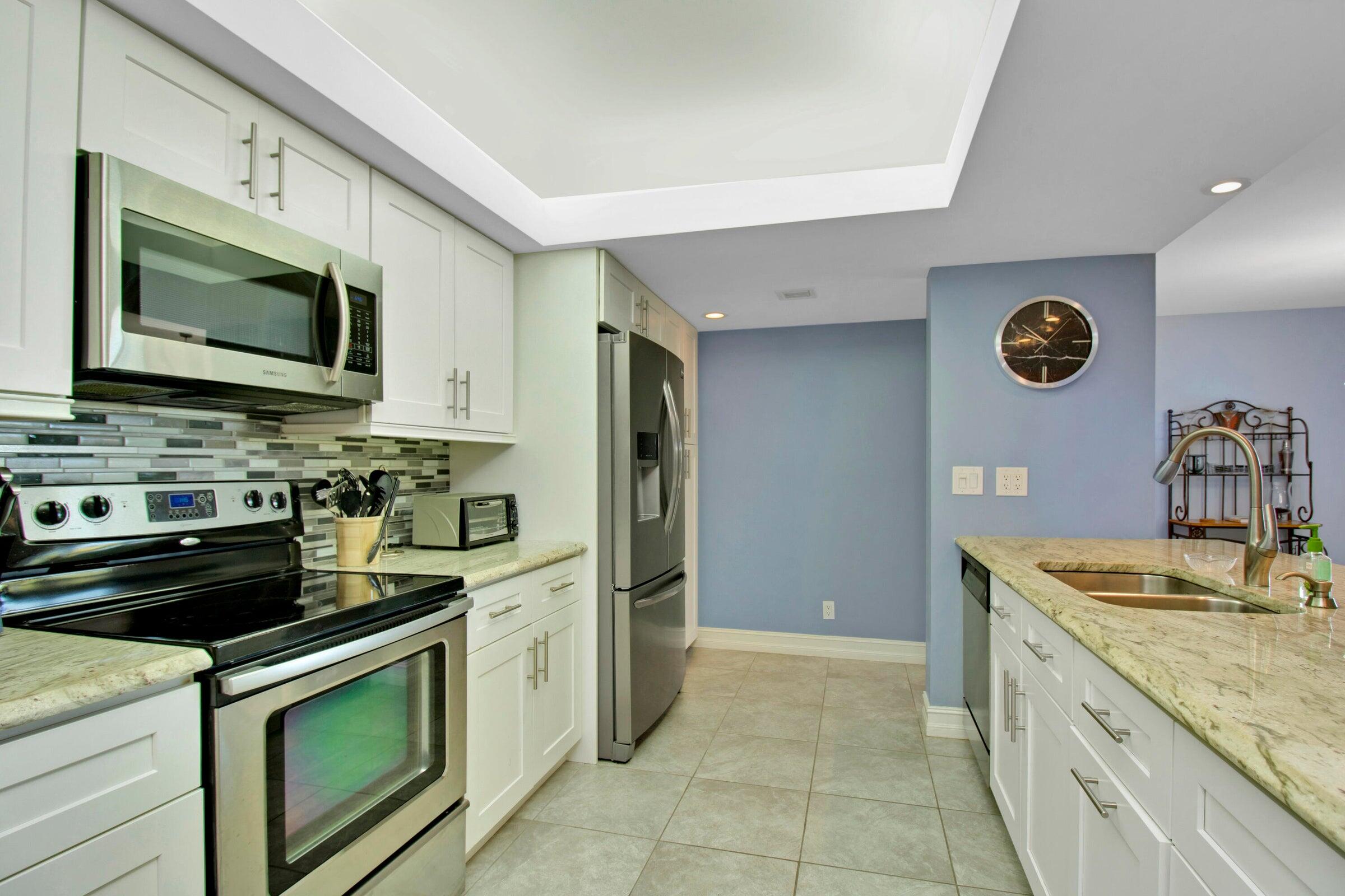 a kitchen with stainless steel appliances granite countertop a sink stove and microwave