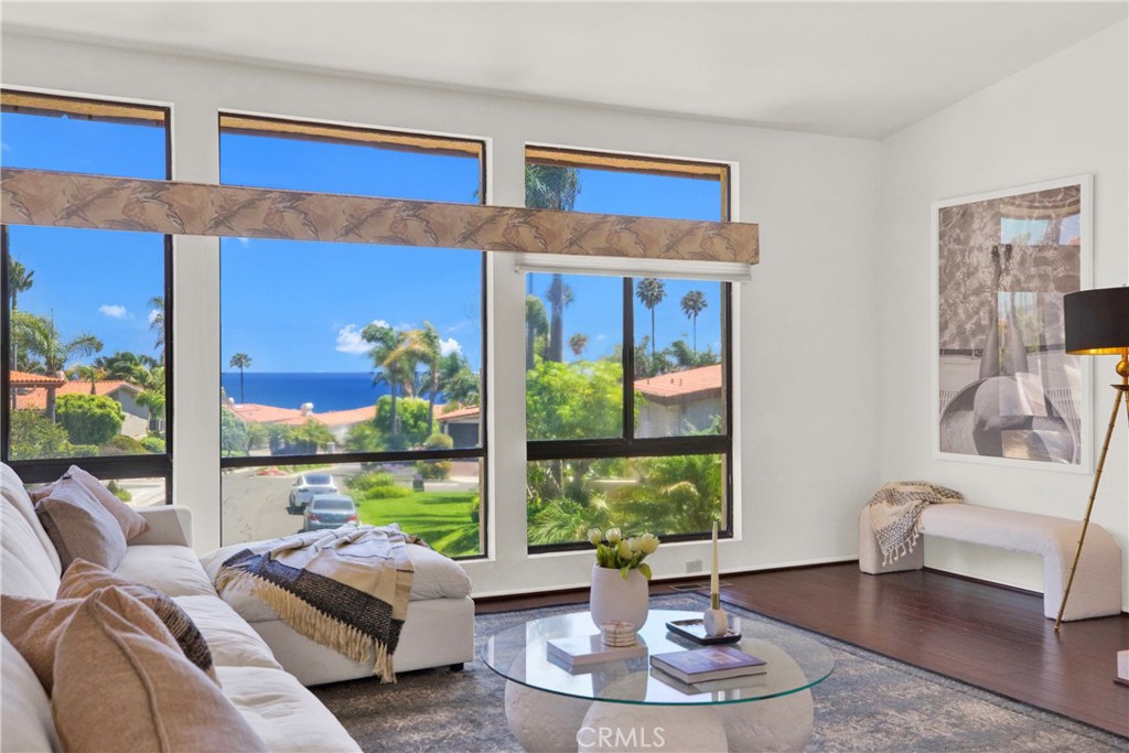 a living room with furniture flowerpot and a floor to ceiling window